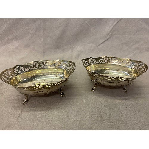 149 - A pair of oval silver bon bon dishes with saw pierced decoration, on four hoof feet - Birmingham 192... 