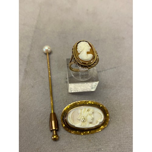 214 - A lady's ring set carved shell cameo to the top, on a 9ct. gold shank, an oval carved coral cameo de... 