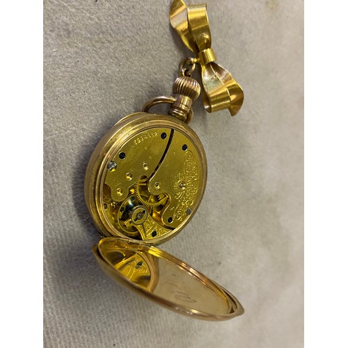 219 - A lady's Waltham open face pocket watch with white enamel dial, in a 9ct. gold case, on a 9ct. gold ... 