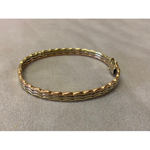 209 - A 9ct. three colour gold bangle