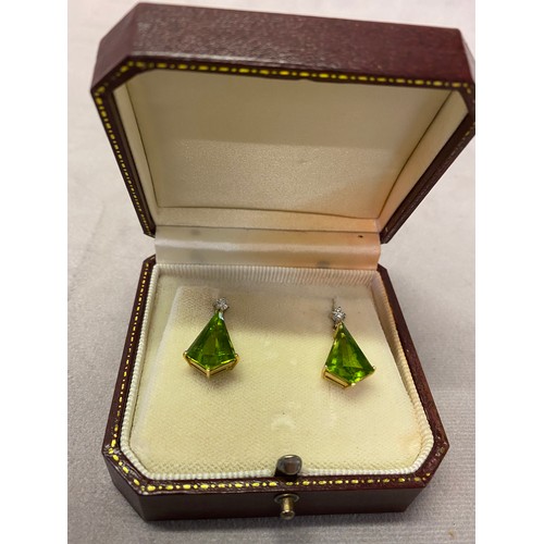 206 - A pair of pendant drop earrings set peridot with diamond tops, mounted in 18ct. gold