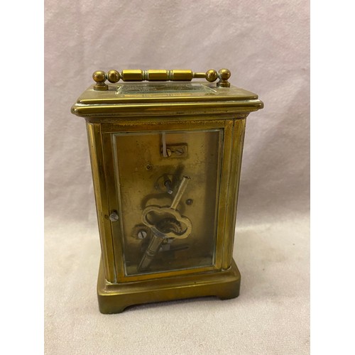 279 - A carriage clock, white enamel dial, in a brass and bevelled glass case - 4 1/4in. high