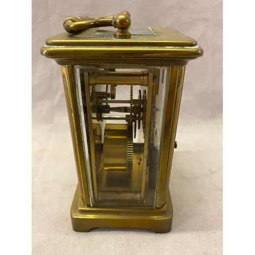 279 - A carriage clock, white enamel dial, in a brass and bevelled glass case - 4 1/4in. high