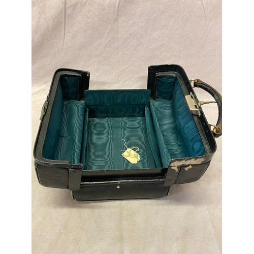 281 - A black leather Gladstone style travelling toilet case with green silk interior - 9 1/2in. wide