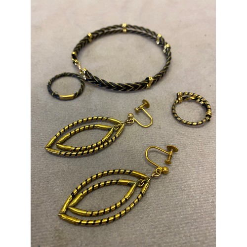 250 - A hair and gold coloured metal mounted bangle, two rings and pair of earrings