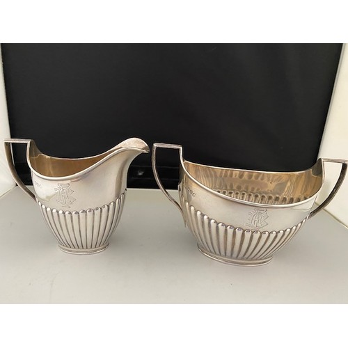 193 - A Victorian silver cream jug and matching double handled sugar basin with half fluted decoration - L... 