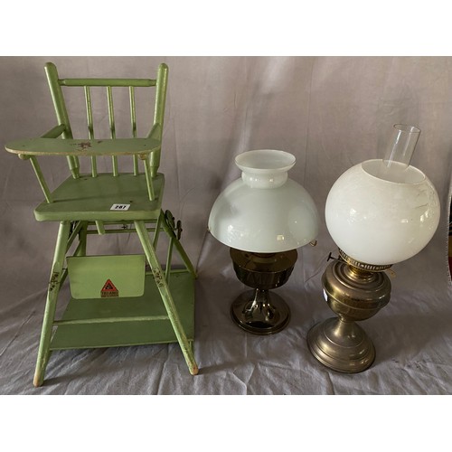 287 - A Triang green painted dolls high chair and two paraffin lamps with chimneys and shades