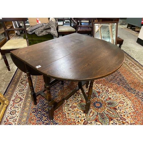 42 - An oak gateleg table fitted two rounded drop flaps, on turned legs and a rectangular wall mirror