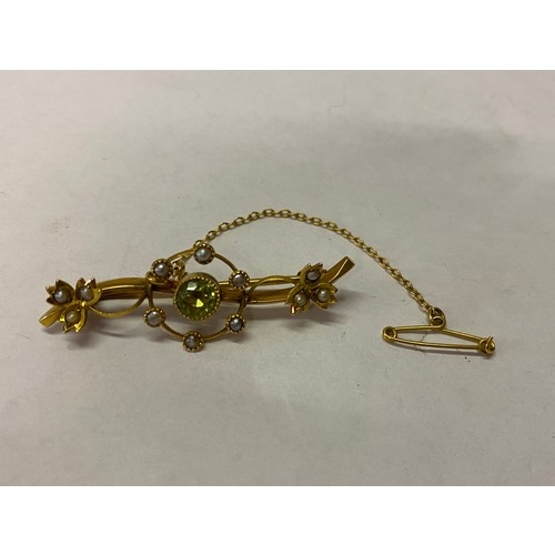 259 - A gold bar brooch set centre peridot surrounded by seed pearls, seed pearl set leaves to each end, i... 