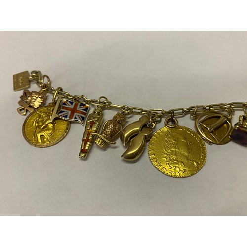 254 - A 14kt. gold bracelet hung with many gold charms including a lizard, owl, clog, enamel Union Jack, s... 