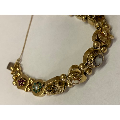 263 - A 14kt. gold bracelet, the shaped links set with semi precious stones, enamel, cameos etc. with bead... 