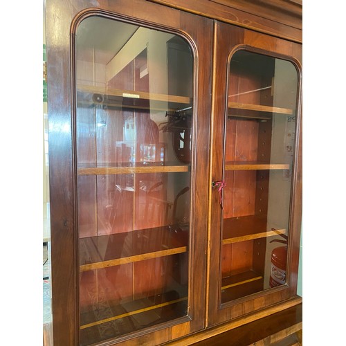 21 - A Victorian mahogany bookcase, the upper part fitted two glass doors enclosing shelves, the base fit... 