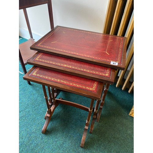 31 - A nest of three reproduction mahogany occasional tables with inset red and gilt tooled leather tops,... 