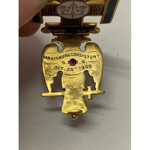 246 - A Continental gold coloured metal Masonic pendant, the front set with an eagle inset red stone, the ... 