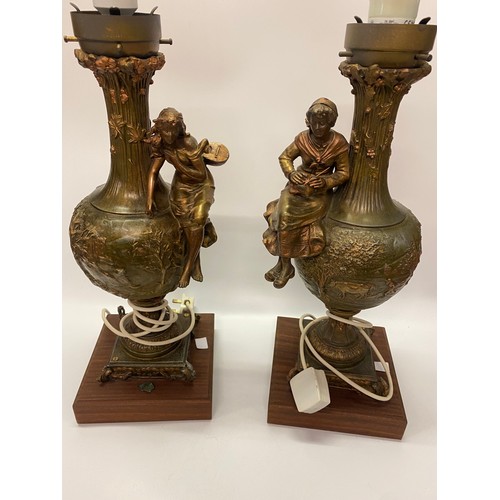 56 - A pair of spelter tablelamp bases of urn form with female figure supports, on wooden bases, complete... 