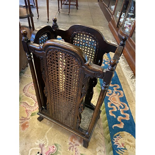 50 - An oak stickstand with scroll decoration and inset cane panels - 16in wide