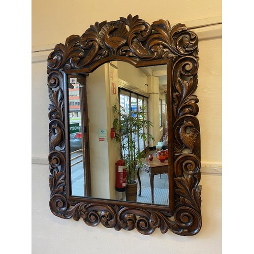 60 - A rectangular wall mirror in a carved wood leaf scroll frame with bird and shell surmount - 35in. x ... 