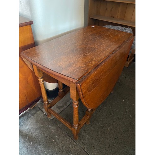 58 - An oak gateleg table fitted two rounded drop flaps, on baluster turned legs - 35in. wide