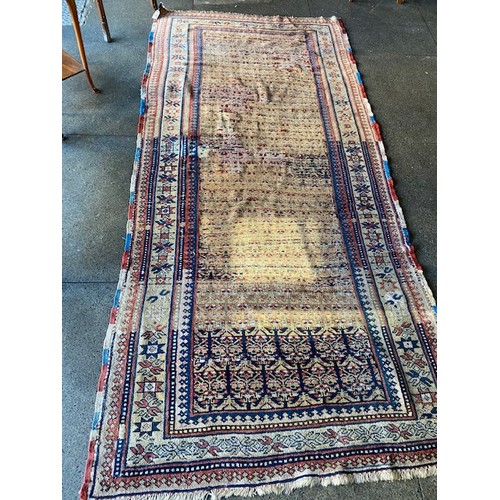 43 - A large Eastern rug, red and blue decoration to the centre and border