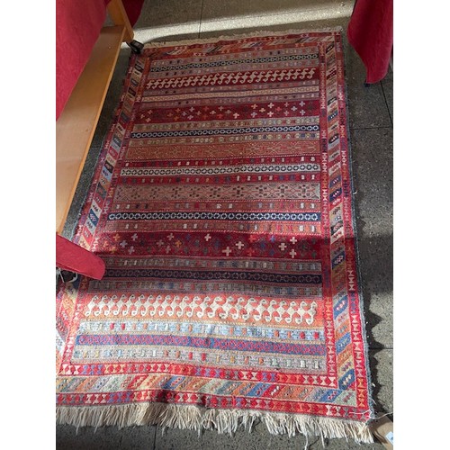 8 - An Eastern rug, red field with geometric bands of stylised decoration, fringed - 75in. x 46in.