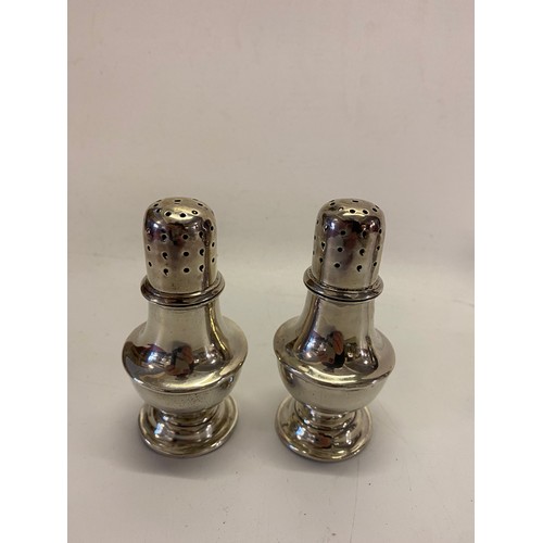 1241 - A pair of small silver vase form sugar castors, on circular feet - Birmingham 1902