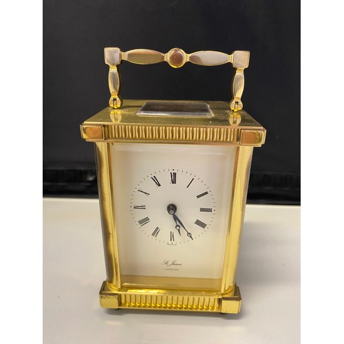 1328 - A carriage clock retailed by St James, white enamel dial, in a lacquered brass and glass case - 4 1/... 