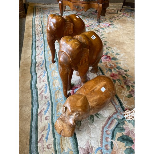 318 - Two hardwood models of elephants - 17in. high, a similar model of a hippo - 17in. wide and a Victori... 