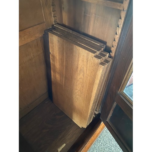 40 - A reproduction Continental walnut veneered bookcase fitted three glass and panelled doors enclosing ... 