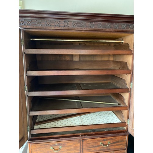 56 - An Edwardian mahogany linen press with blind fret carved frieze, fitted two panelled doors enclosing... 