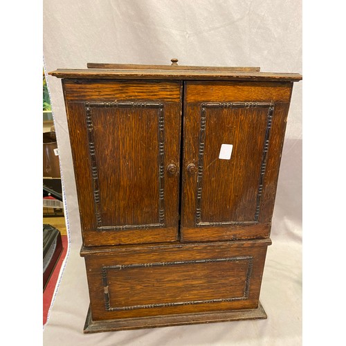 50 - A gramophone retailed by Willis in a small oak cabinet fitted two panelled doors - 14in. wide