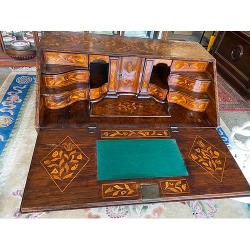 75 - An antique Dutch marquetry bureau of bombe form, hinged fall front enclosing stepped interior above ... 