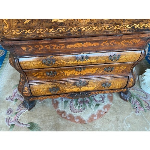 75 - An antique Dutch marquetry bureau of bombe form, hinged fall front enclosing stepped interior above ... 