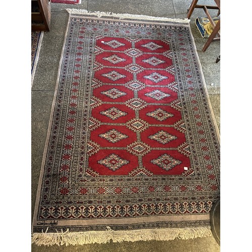 1 - A Bokhara rug, red and grey with fourteen medallions to the centre, fringed - 78in. x 52in. and a sm... 