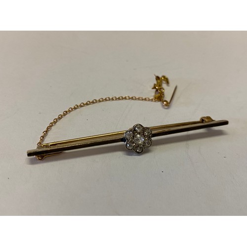 213 - A gold bar brooch, the top set with a daisy cluster of diamonds