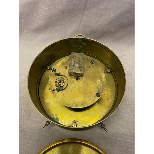 257 - A clock with white enamel dial, in a brass case, on short feet