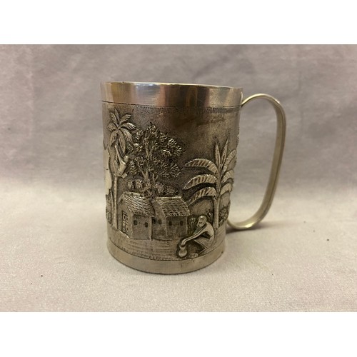 170 - A Far Eastern silver coloured metal christening mug with 'C' scroll handle, repousse decorated figur... 