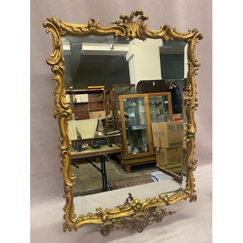 55 - A rectangular bevelled wall mirror in a gilt leaf scroll frame - 24in. x 18in.
