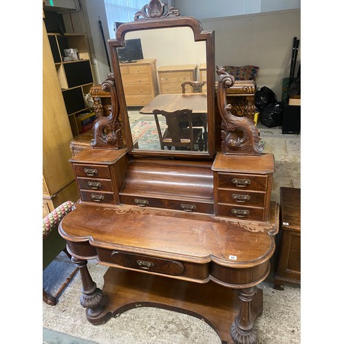 60 - A Victorian mahogany dressing table with swing mirror, scroll supports seven jewel drawers, the shap... 