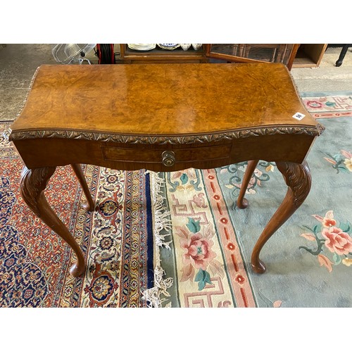 50 - A reproduction walnut sidetable with serpentine shaped front, fitted frieze drawer, on cabriole legs... 