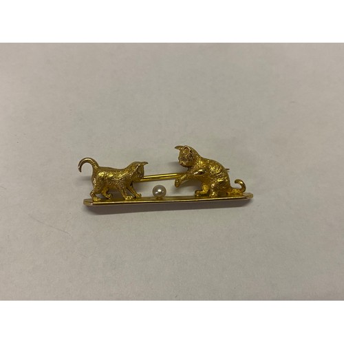 212 - A gold coloured metal bar brooch modelled as two kittens with diamond chip set eyes playing with a b... 