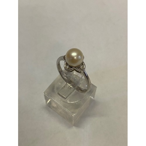 264 - A lady's ring set centre pearl and four diamonds, on a 9ct. white gold shank