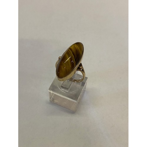 270 - A lady's ring set oval tigers eye agate, on a 9ct. gold shank