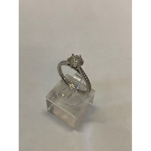 277 - A lady's ring set solitaire diamond, diamond set shoulders, on a platinum shank