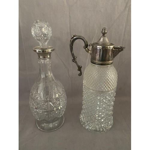 166 - A decanter with plain silver collar and one other with silver plated collar, lid and handle