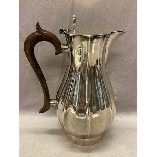 219 - A panelled baluster form silver water jug with scroll thumbpiece - Sheffield 1936, makers marks for ... 