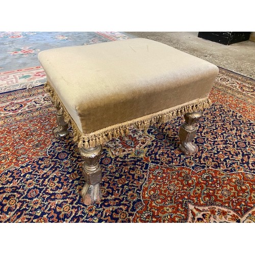 107 - A rectangular footstool raised on silver painted turned legs with scroll feet