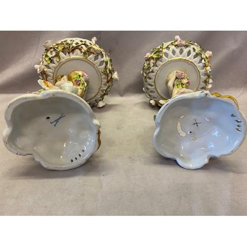 106 - A pair of 'Meissen' porcelain comports with pierced basket weave and flower encrusted bowls, cupid s... 