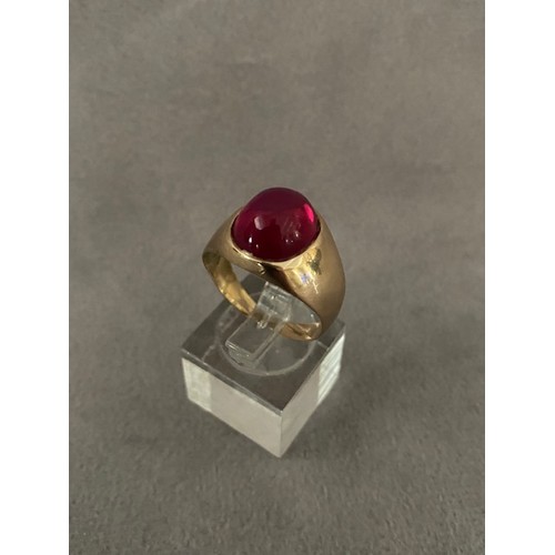 315 - A gentleman's signet ring set red cabochon stone, on a gold coloured metal shank