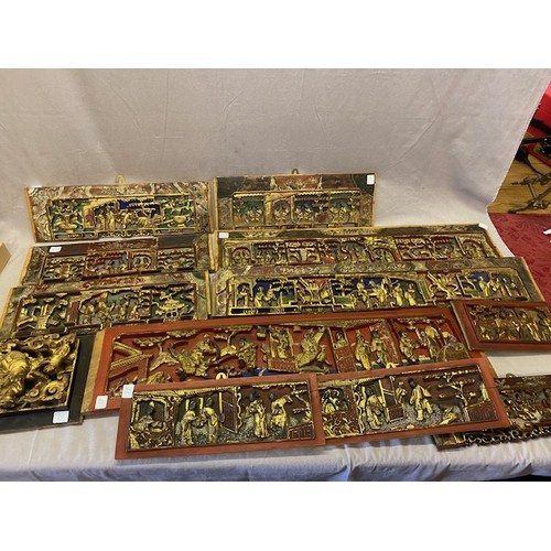 63 - Eleven Eastern red and gold carved wall panels depicting many figures