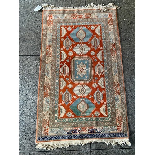 1 - An Eastern rug, red, blue and cream with geometric border, fringed - 60in. x 36in.